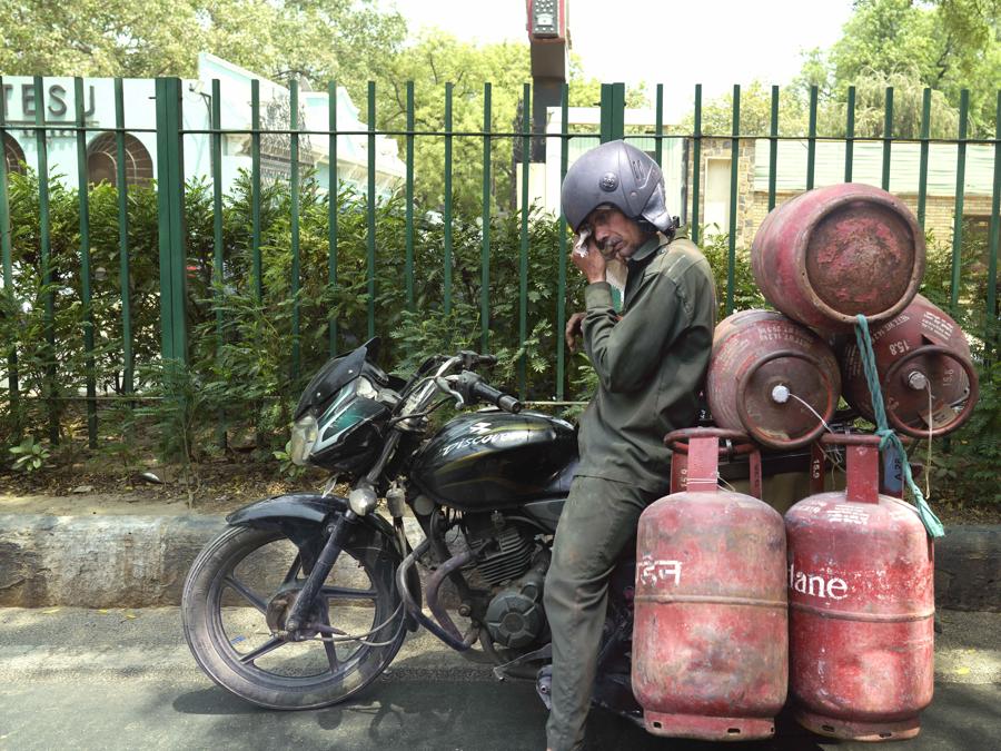 Un addetto alla consegna delle bombole di gas si asciuga il sudore mentre prende una pausa all’ombra di un albero in una calda giornata estiva a Nuova Delhi. (AP Photo/Manish Swarup)