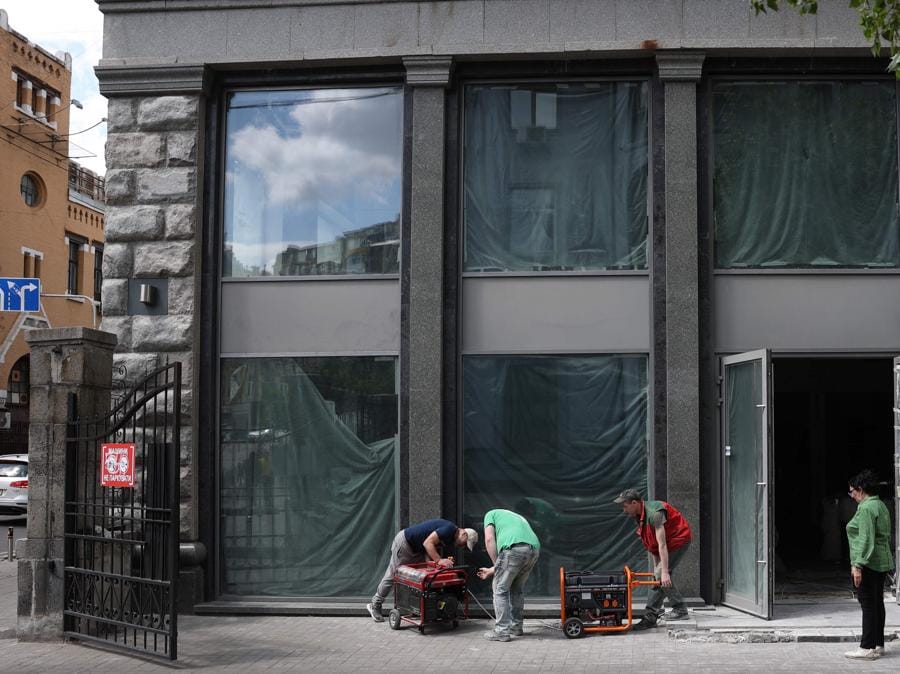 I lavoratori installano un generatore di benzina per continuare a lavorare durante un blackout nel centro di Kiev. (Photo by Anatolii STEPANOV / AFP)