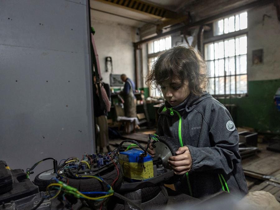 Yesenia Mamonov, 10 anni, testa i motori elettrici nell’officina di suo padre Dmytro Mamonov dove producono veicoli di evacuazione medica telecomandati per i militari, in una località sconosciuta nell’Ucraina centrale. REUTERS/Thomas Peter