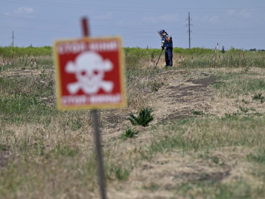 Uno sminatore della ONG HALO Trust rimuove le mine in un campo fuori dal villaggio di Snigurivka, nella regione di Mykolaiv. (Photo by Genya SAVILOV / AFP)