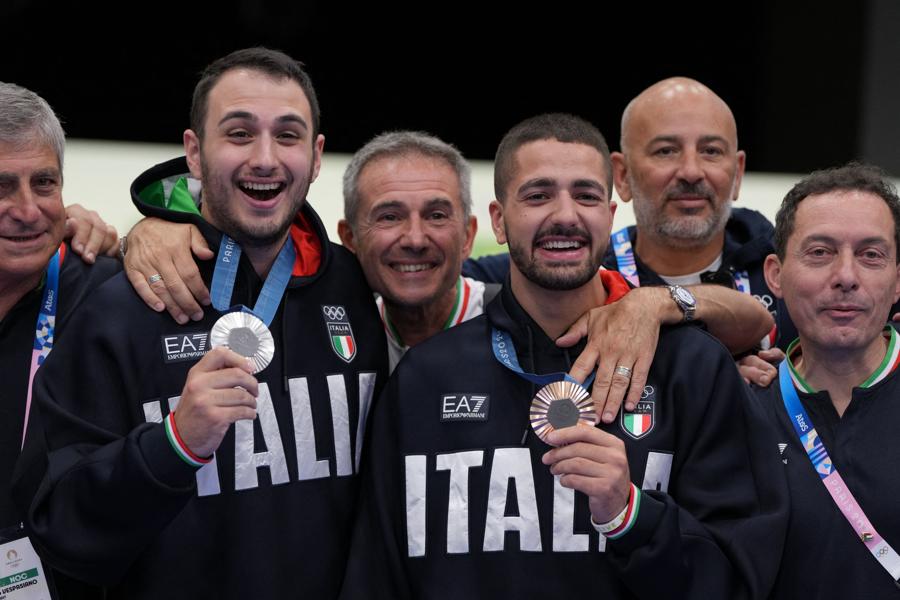 28 luglio 2024 -  Tiro con la pistola 10 metri: la medaglia d’Argento Federico Nilo Maldini (secondo da sinistra) e la medaglia di Bronzo Paolo Monna (quarto da sinistra) posano con gli allenatori. (REUTERS/Amr Alfiky)