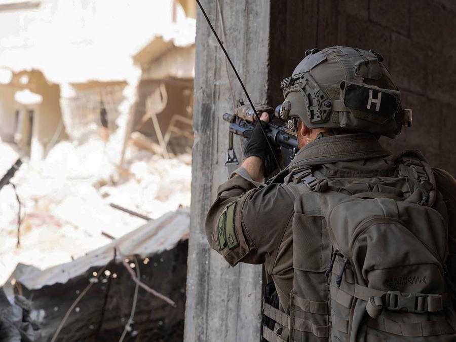 Un soldato israeliano  punta il suo fucile da un edificio nella Striscia di Gaza. (Photo by Israeli Army / AFP)