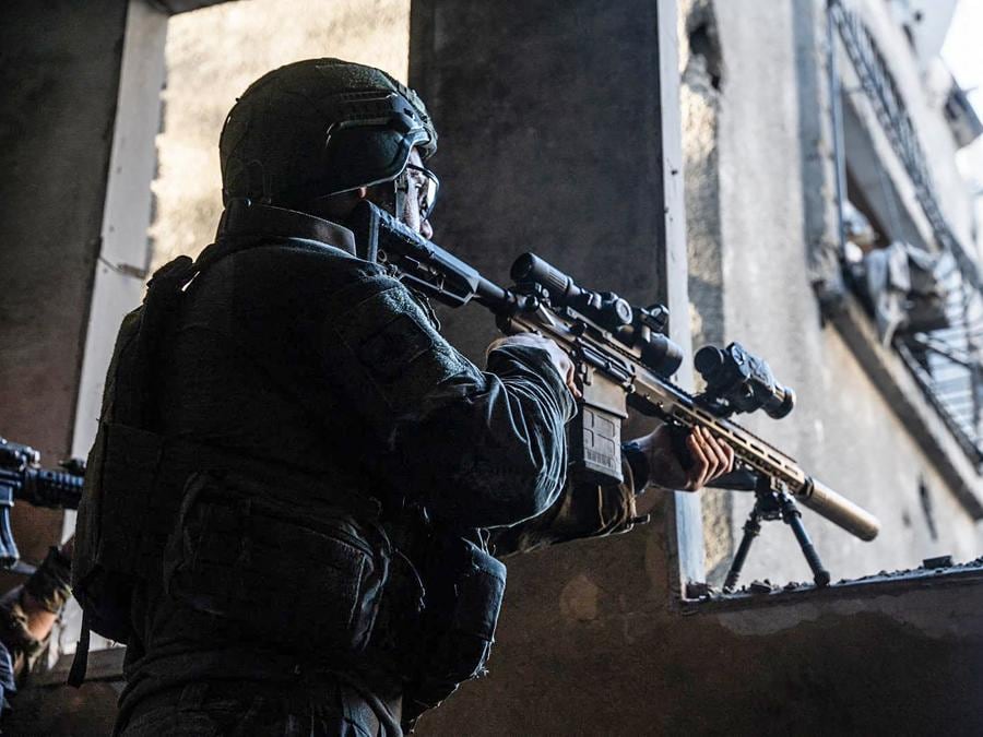 Un soldato israeliano  punta il suo fucile da un edificio nella Striscia di Gaza. (Photo by Israeli Army / AFP)