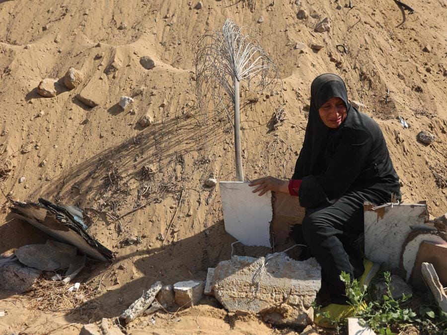 Una donna piange dopo aver trovato la tomba improvvisata di suo figlio mentre tornava nel quartiere Al-Sinaa, nella parte occidentale di Gaza City. (Photo by Omar AL-QATTAA / AFP)