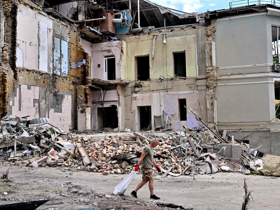 Un volontario trasporta un sacco pieno di detriti a Okhmatdyt, il più grande ospedale pediatrico dell’Ucraina, a Kiev. (Photo by Sergei SUPINSKY / AFP)