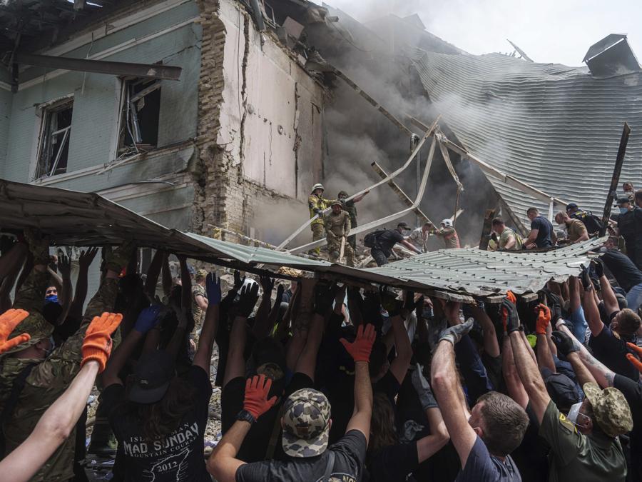 I soccorritori lavorano insieme per rimuovere i detriti durante un’operazione di ricerca dei sopravvissuti presso l’ospedale pediatrico Okhmatdyt colpito da un missile russo, a Kiev. (AP Photo/Evgeniy Maloletka)