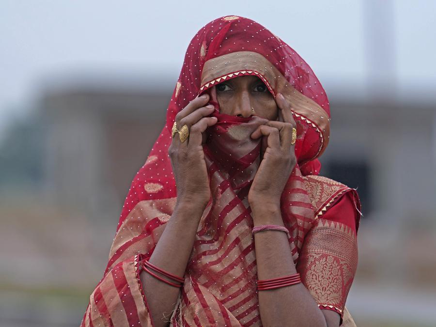 Una donna osserva i membri di una squadra forense indagare sulla scena un giorno dopo una fuga mortale, nel villaggio di Fulrai, nel distretto di Hathras, Uttar Pradesh, India. Migliaia di persone presenti a un raduno religioso si sono precipitate a lasciare una tenda improvvisata, dando il via a una fuga precipitosa martedì che ha ucciso più di cento persone e ne ha ferite decine. (AP Photo/Rajesh Kumar Singh) Associated Press/LaPresse