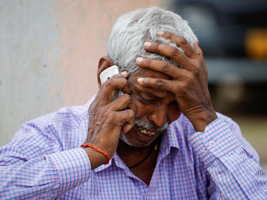 Chedilal, 65 anni, padre di Ruby morta in una fuga precipitosa, parla al telefono mentre piange fuori da un ospedale nel distretto di Hathras, nello stato settentrionale dell’Uttar Pradesh. (REUTERS/Anushree Fadnavis)