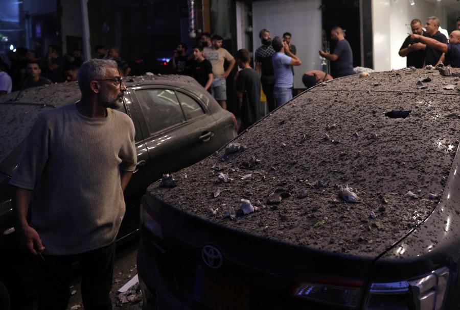 Veicoli coperti di detriti vicino al luogo di un attacco militare israeliano nella periferia di Beirut. (AFP)