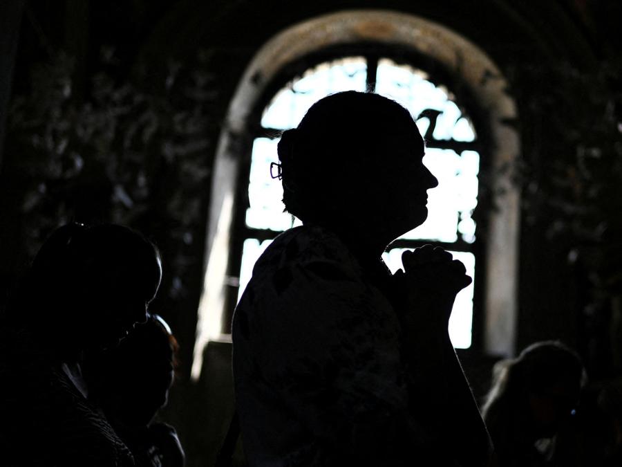 Alcune persone pregano durante il servizio funebre per la dottoressa nefrologa Svitlana Lukianchuk, 30 anni, che è stata uccisa da un attacco missilistico russo all’ospedale pediatrico Ohmatdyt di Kiev. (REUTERS/Stringer)