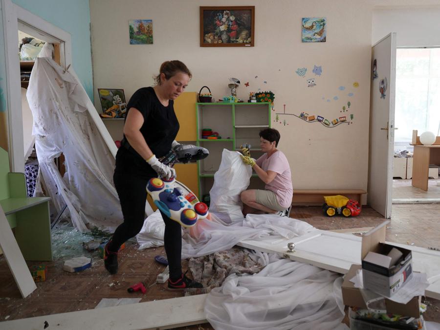 Gli educatori sistemano i giocattoli recuperati da un asilo distrutto da un attacco missilistico, a Kiev. (Photo by Anatolii Stepanov / AFP)