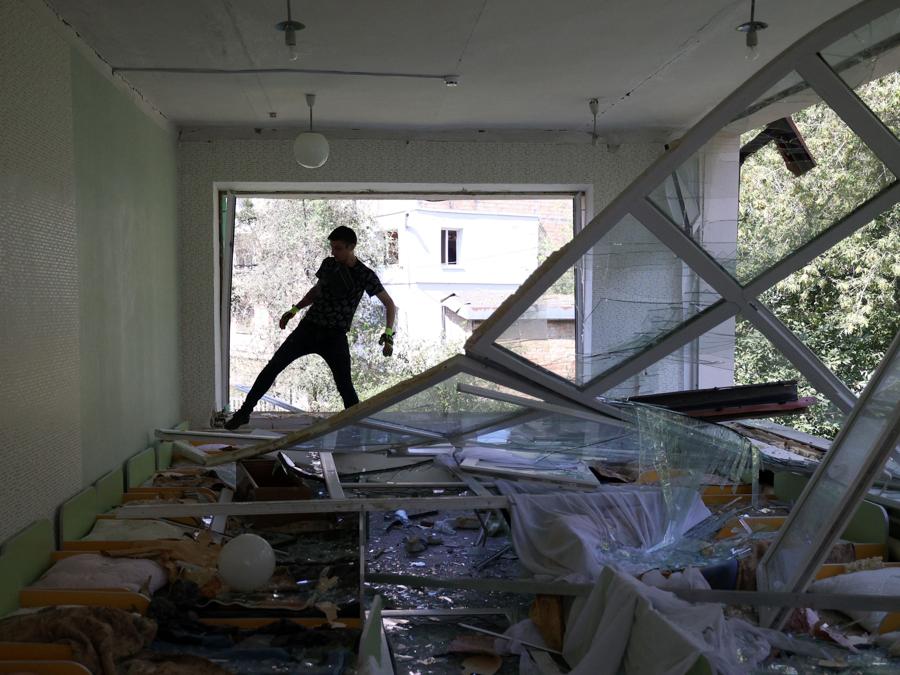 Un volontario rimuove i detriti dalla camera da letto di un asilo distrutto da un attacco missilistico, a Kiev. (Photo by Anatolii Stepanov / AFP)