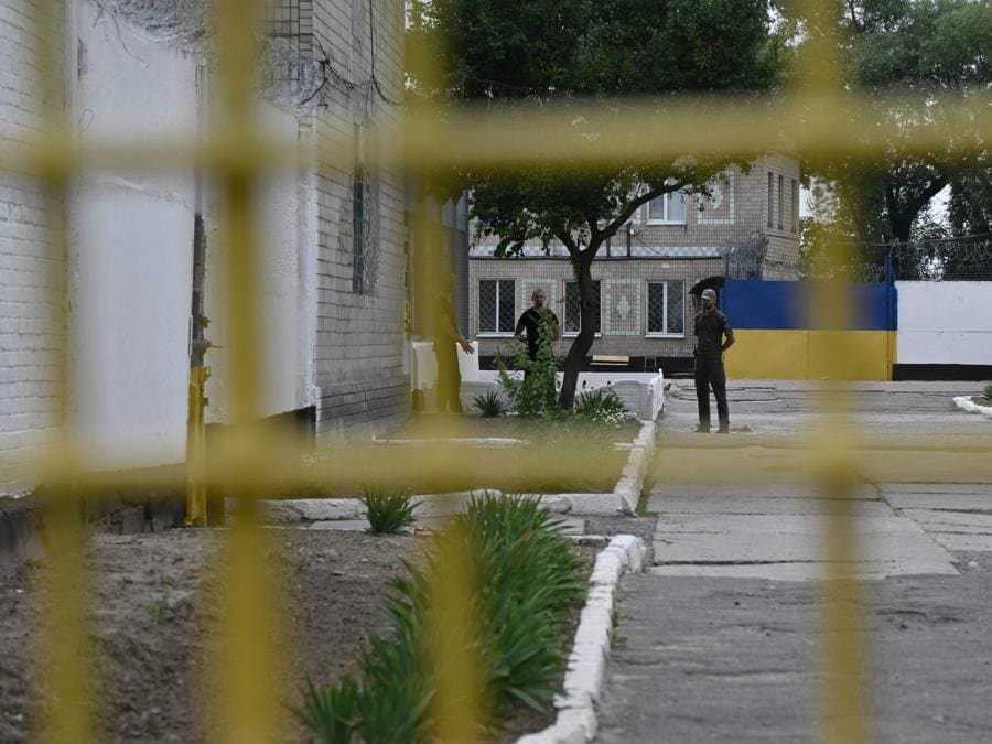 Alcuni detenuti ucraini  e una guardia aspettano in un cortile della colonia penale di Boryspil fuori dalla città di Boryspil, nella regione di Kiev. L’Ucraina è carente di manodopera mentre la guerra con la Russia è giunta al suo terzo anno e sta moltiplicando gli sforzi per aumentare i numeri, anche con regole più rigorose sulla mobilitazione e consentendo ai cittadini di combattere. Il ministero della Giustizia afferma che oltre cinquemila uomini nelle carceri di tutto il paese hanno chiesto di arruolarsi da quando è stata approvata una nuova legge a maggio. La legge esclude solo le persone condannate per i reati più gravi, tra cui violenza sessuale, omicidio di due o più persone e corruzione grave. (Photo by Genya Savilov / AFP)