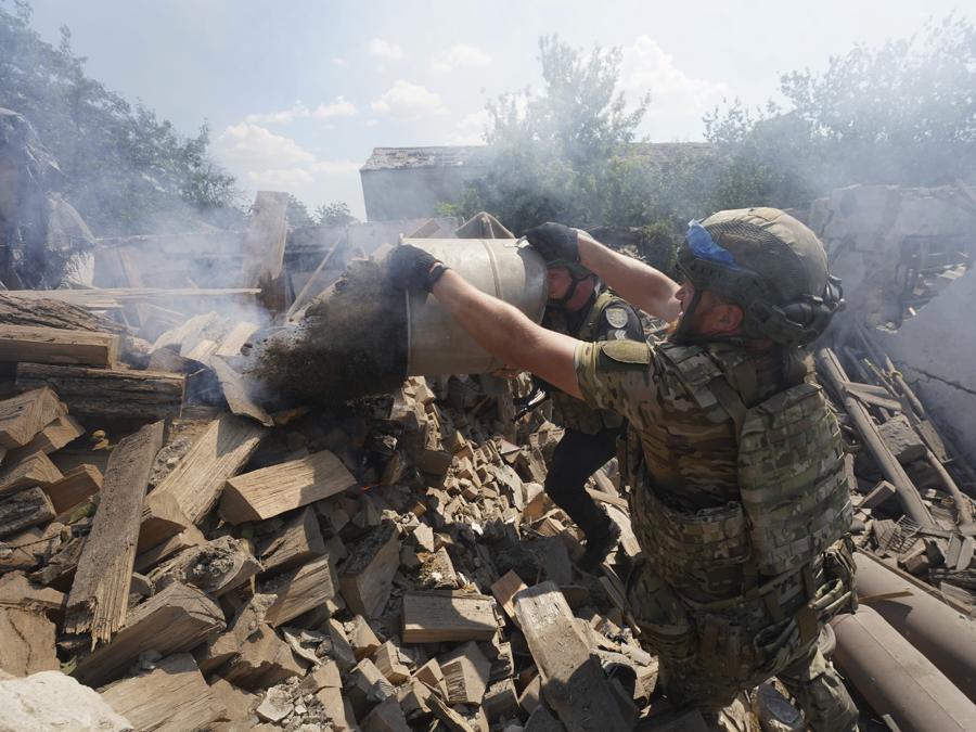 Gli agenti di polizia spengono un incendio dopo l’attacco aereo russo sul quartiere residenziale di Bilyi Kolodiaz, regione di Kharkiv. (AP Photo/Andrii Marienko)