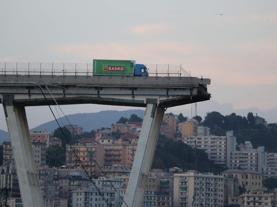 Un camion si ferma sul bordo del ponte autostradale Morandi crollato. (Photo by Valery HACHE / AFP)