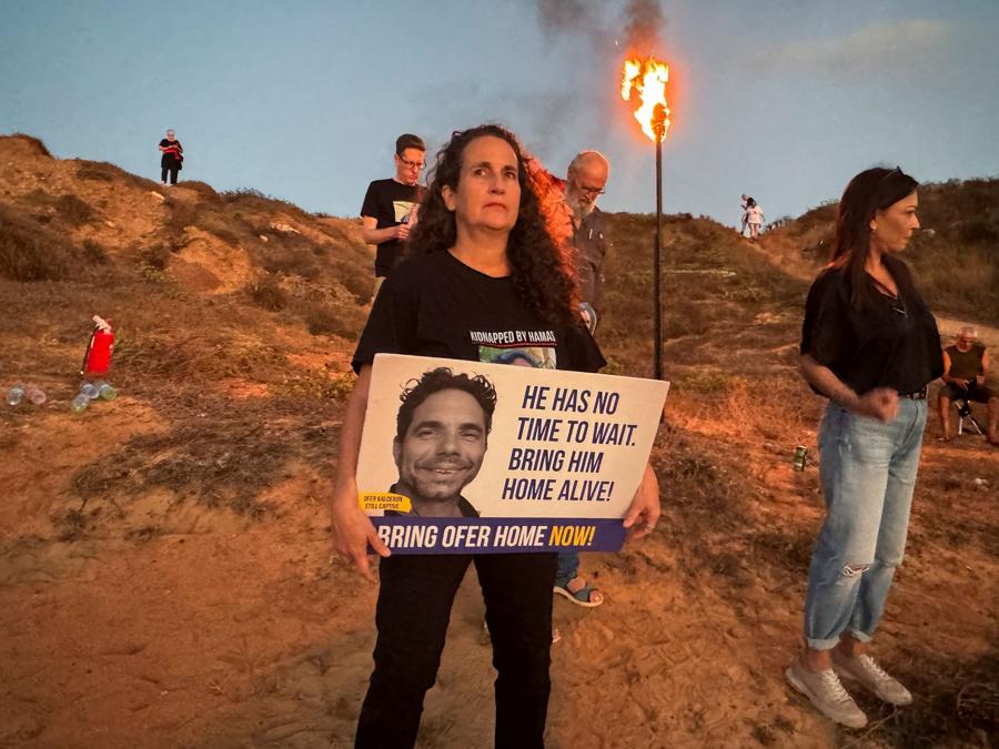 Hadas Kalderon tiene un cartello raffigurante il padre dei suoi figli, Ofer Kalderon, in occasione di un evento a sostegno degli ostaggi tenuti a Gaza e che celebra i 300 giorni dall’attacco mortale del 7 ottobre. (REUTERS/Ilan Rosenberg)