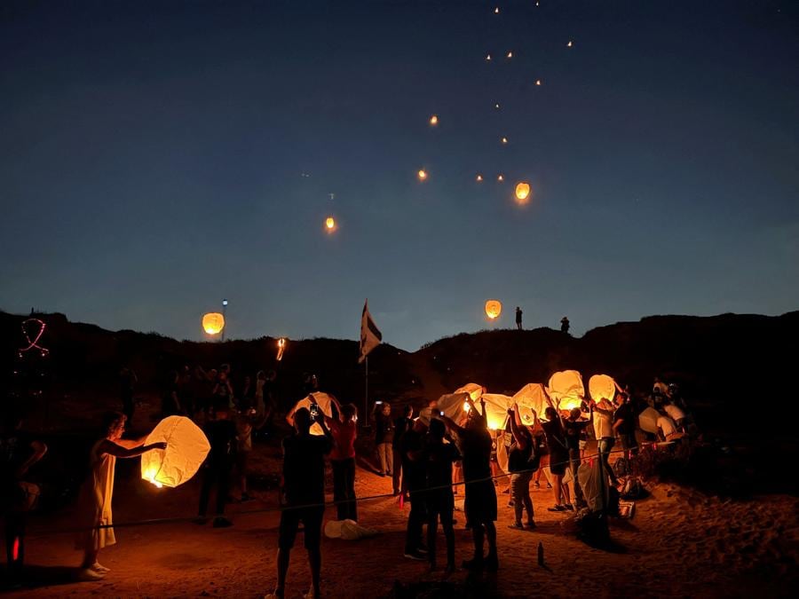 I sostenitori degli ostaggi tenuti a Gaza lanciano 300 lanterne in cielo per celebrare i 300 giorni dall’attacco mortale del 7 ottobre,  su una spiaggia di Tel Aviv. (REUTERS/Ilan Rosenberg)