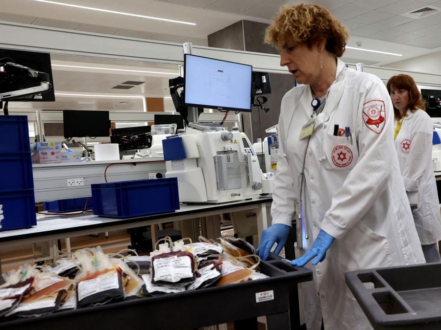 Il personale medico lavora presso la banca del sangue del centro principale del servizio di emergenza nazionale Magen David Adom (Stella Rossa di David) israeliano, nella città centrale israeliana di Ramla, vicino a Tel Aviv. (Photo by Gil Cohen-Magen / AFP)