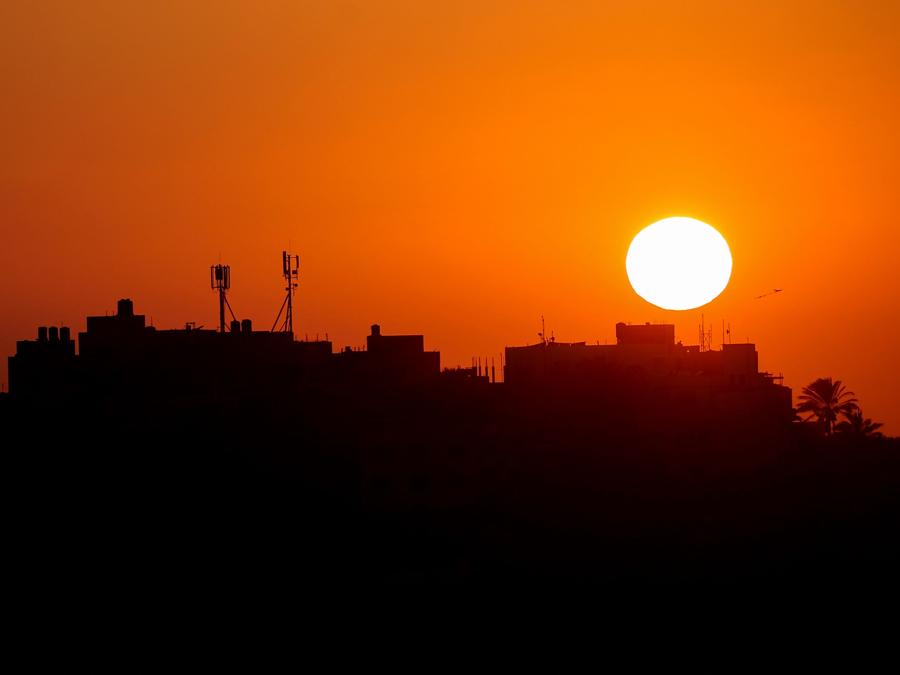 Il sole tramonta dietro il campo profughi palestinese di al-Maghazi, nel centro della Striscia di Gaza. (Photo by Eyad BABA / AFP)