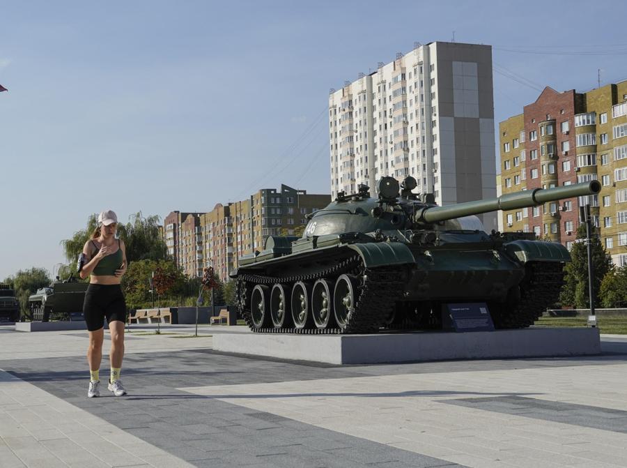Una donna del posto corre vicino al monumento di un carro armato russo a Kursk, Russia. EPA/STRINGER