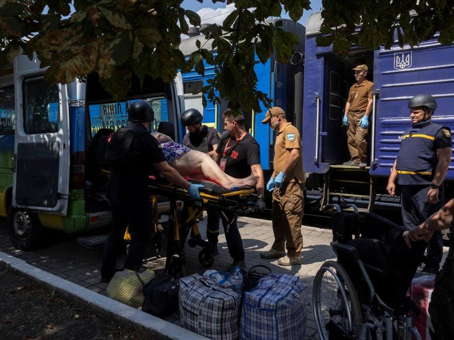 I volontari di East SOS trasportano una donna alla stazione ferroviaria di Pokrovsk, mentre le forze russe avanzano in prima linea nella regione di Donetsk. (REUTERS/Thomas Peter)