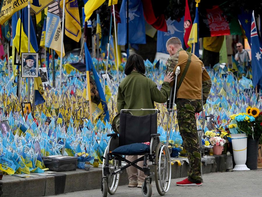 A  Kiev, un militare ucraino con una gamba amputata si commuove mentre  visita un memoriale improvvisato per i soldati ucraini caduti in Piazza Indipendenza. (Photo by Sergei Supinsky / AFP)
