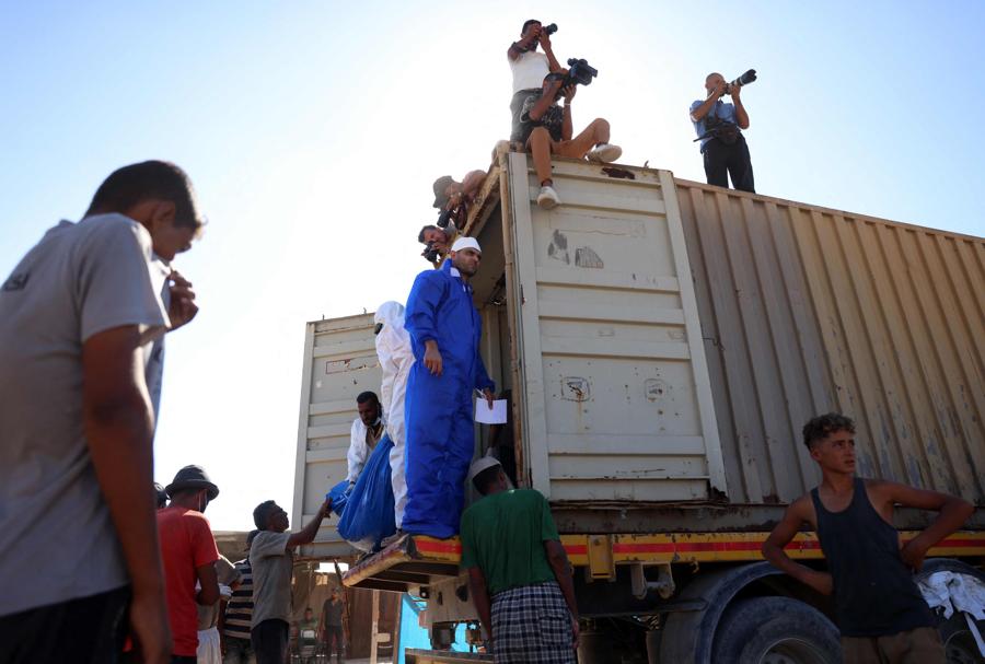 Un camion, che secondo il ministero della Sanità palestinese è entrato nella Striscia di Gaza da Israele il giorno prima, trasporta 88 corpi in attesa che vengano scaricati e sepolti in una fossa comune a Khan Yunis. (AFP)