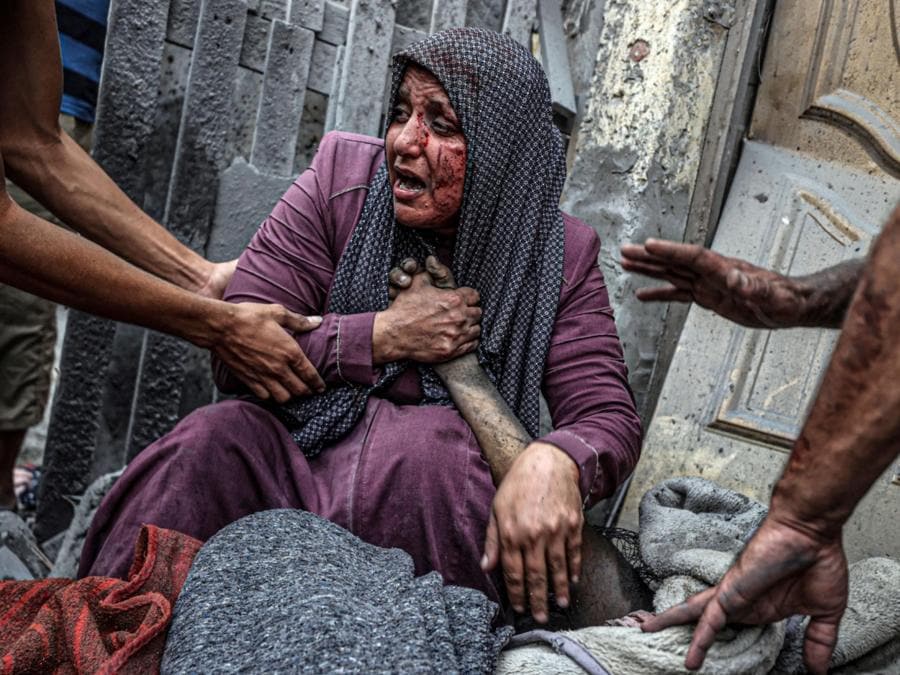 La disperazione di una donna ferita dagli attacchi aerei israeliani nel quartiere Ridwan di Gaza City, sopraffatta dal dolore accanto al corpo senza vita di una persona amata. ANSA