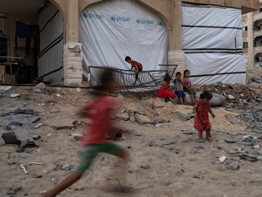 Alcuni bambini palestinesi tra le macerie di un edificio distrutto nel campo profughi di Khan Yunis, nel sud della Striscia di Gaza. EPA/HAITHAM IMAD
