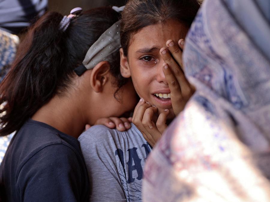 I bambini piangono  a seguito di un attacco israeliano contro una scuola che ospitava palestinesi sfollati a Falluja, vicino al campo profughi di Jabalia, nel nord della Striscia di Gaza. (Photo by Omar AL-QATTAA / AFP)