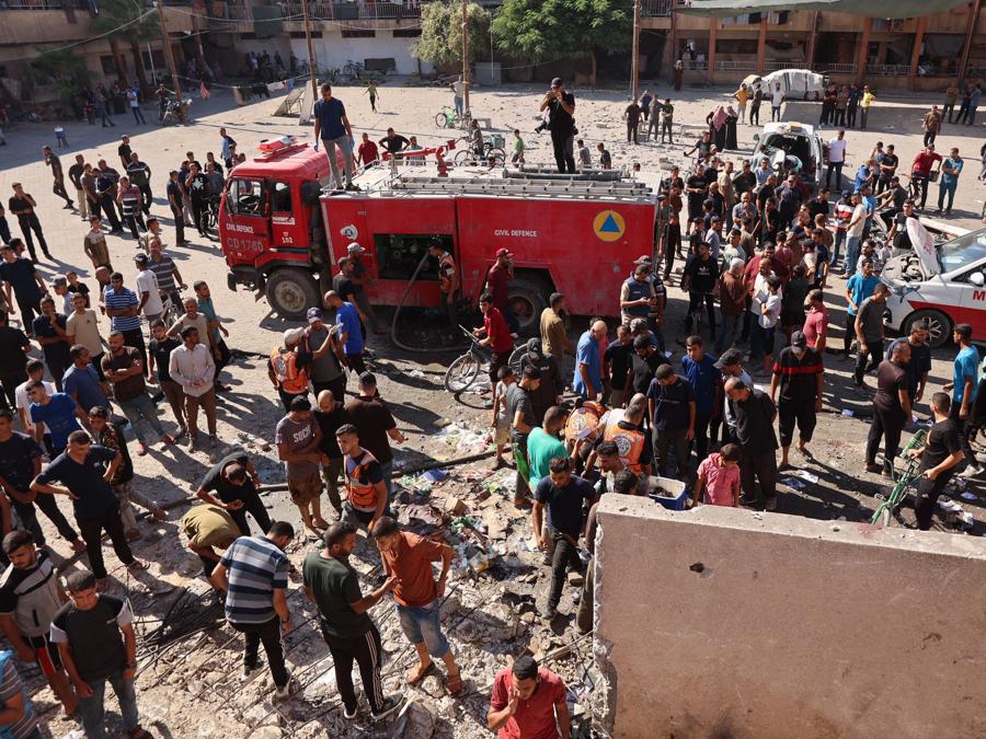 Persone e soccorritori verificano i danni a seguito di un attacco israeliano contro una scuola che ospitava palestinesi sfollati a Falluja, vicino al campo profughi di Jabalia, nel nord della Striscia di Gaza. (Photo by Omar AL-QATTAA / AFP)