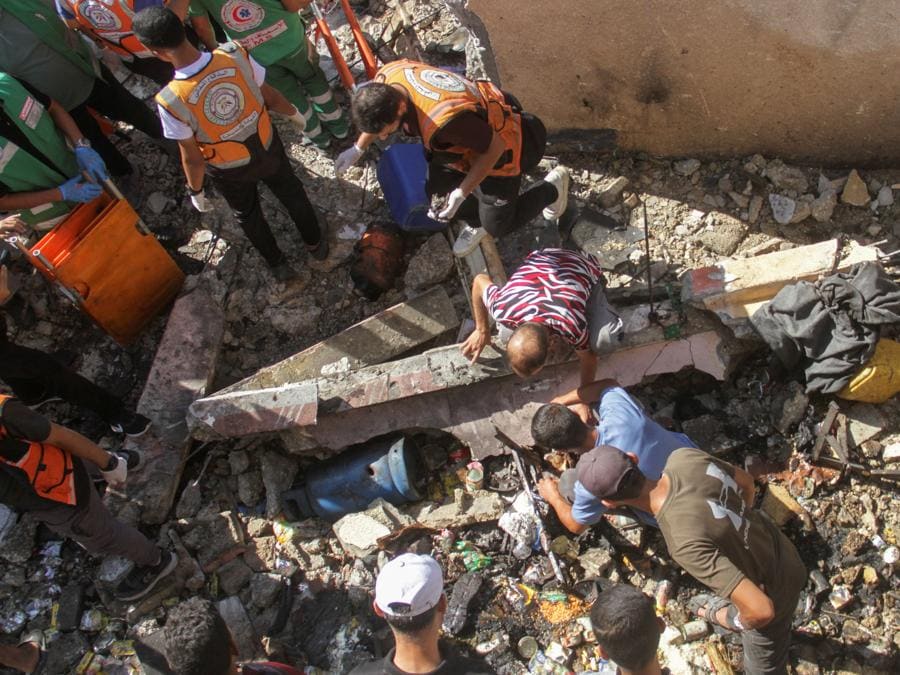 Palestinesi ispezionano il luogo di un attacco israeliano contro una scuola che ospitava sfollati a Jabalia, nel nord della Striscia di Gaza. REUTERS/Mahmoud Issa