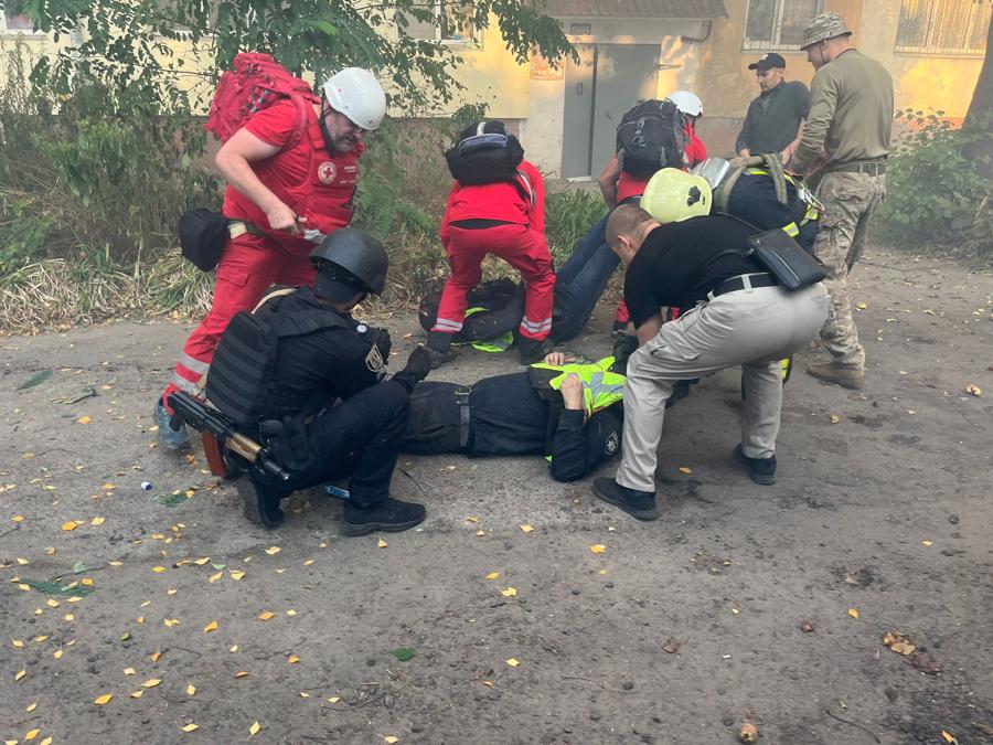 Paramedici e agenti di polizia aiutano i loro compagni di squadra feriti nell’area di un edificio ospedaliero che è stato colpito due volte da droni kamikaze russi a Sumy, Ucraina. Press service of the State Emergency Service of Ukraine/Handout via REUTERS