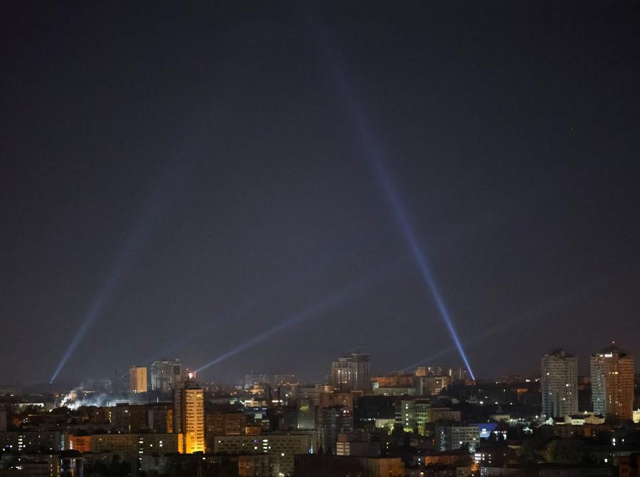 Il personale di servizio ucraino utilizza i proiettori mentre cerca i droni nel cielo sopra il centro della città durante un attacco di droni russi a Kiev. REUTERS/Gleb Garanich