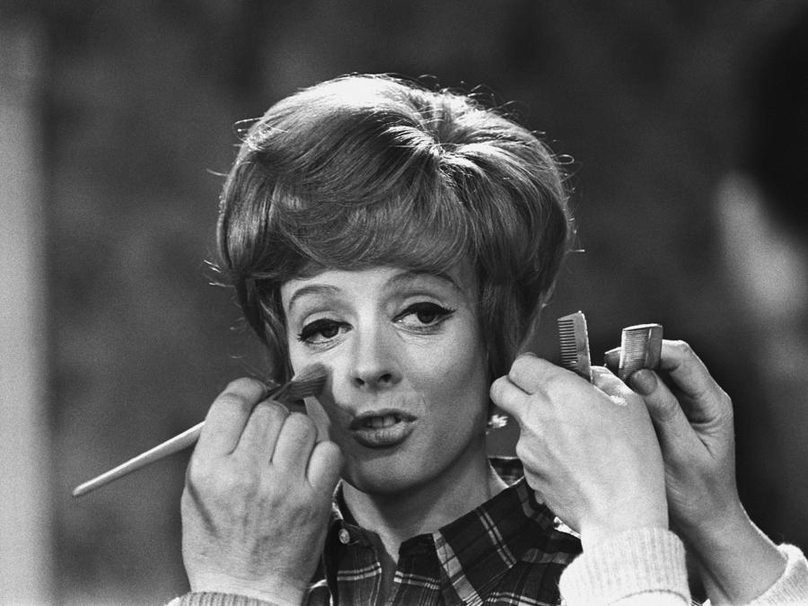 Truccatori e parrucchieri aggiungono il tocco finale all’attrice britannica Maggie Smith prima di affrontare la telecamera con Peter Ustinov nella commedia “Hot Millions” girata agli Elstree Studios, Inghilterra, il 12 gennaio 1968. (AP Photo/Bob Dear, File)