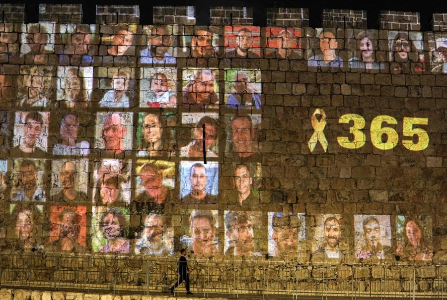 Lungo le mura della città vecchia di Gerusalemme vengono proiettate le immagini delle vittime degli attacchi del 7 ottobre 2023 insieme al numero 365, che indica il numero di giorni trascorsi. (AFP)