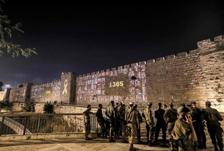 Lungo le mura della città vecchia di Gerusalemme vengono proiettate le immagini delle vittime degli attacchi del 7 ottobre 2023 insieme al numero 365, che indica il numero di giorni trascorsi. (AFP)