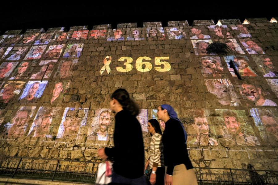 Lungo le mura della città vecchia di Gerusalemme vengono proiettate le immagini delle vittime degli attacchi del 7 ottobre 2023 insieme al numero 365, che indica il numero di giorni trascorsi. (AFP)