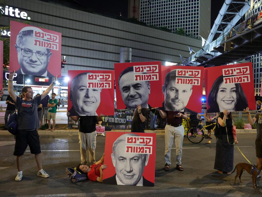 I dimostranti tengono in mano striscioni raffiguranti membri del governo del primo ministro israeliano Netanyahu con la scritta “Death cabinet” (gabinetto della morte) durante una protesta tenuta dalle famiglie degli ostaggi israeliani, tenuti prigionieri da Hamas a Gaza, e dai loro sostenitori che chiedono un cessate il fuoco e il loro rilascio vicino all’area di Kirya, a Tel Aviv. Secondo l’esercito israeliano, 101 ostaggi israeliani rimangono prigionieri nella Striscia di Gaza. Le manifestazioni in Israele sono state critiche nei confronti della gestione della crisi da parte del governo israeliano, chiedendo l’immediato rilascio di tutti gli ostaggi. (EPA/Abir Sultan)