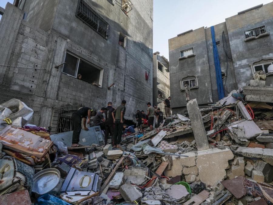 Palestinesi cercano corpi e sopravvissuti tra le macerie della casa distrutta della famiglia Al-Tilbany a seguito di un attacco aereo israeliano nel campo profughi di Al-Maghazi nella Striscia di Gaza. EPA/MOHAMMED SABER