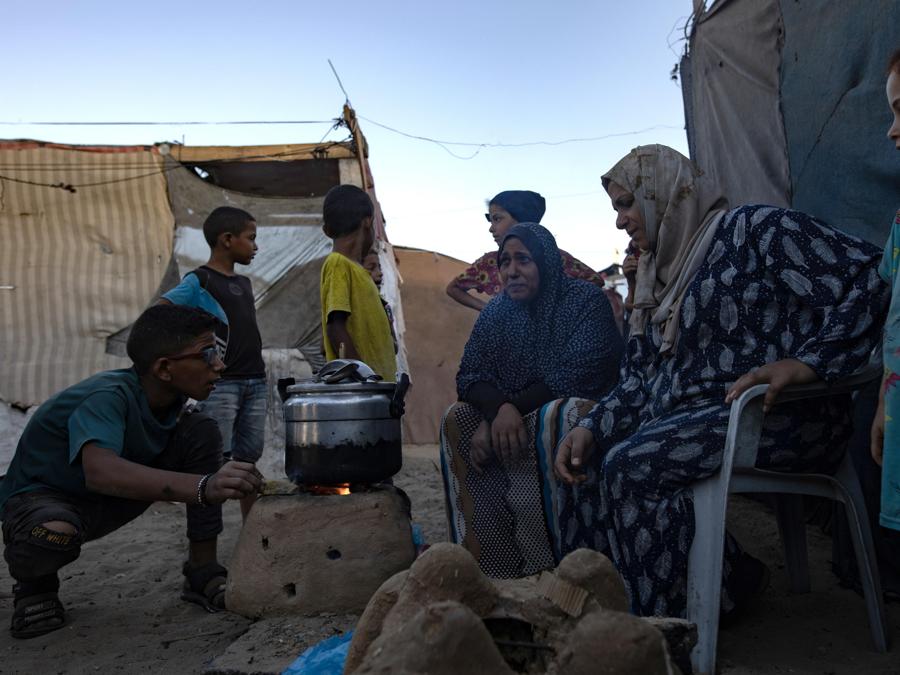 Palestinesi sfollati  cucinano fuori da una tenda in un campo a Khan Younis, nel sud della Striscia di Gaza. EPA/HAITHAM IMAD
