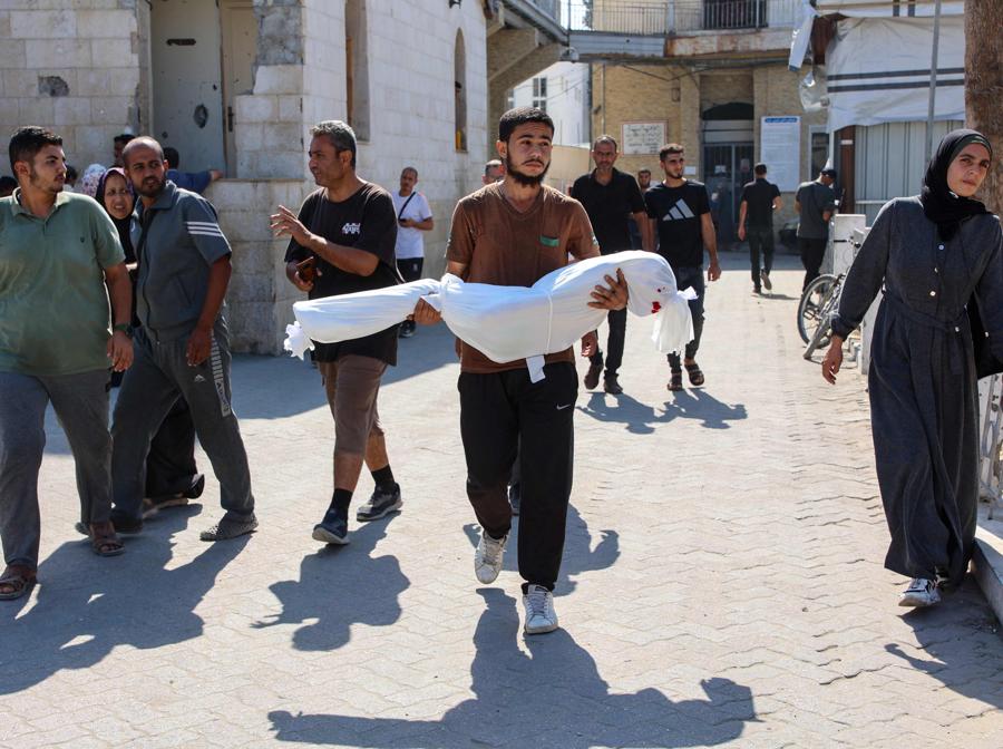 Un parente trasporta il corpo avvolto nel sudario della bambina di dieci anni Sama al-Debs, uccisa durante un’operazione dell’esercito israeliano nel campo profughi di Jabalia, nel centro della Striscia di Gaza, prima del suo funerale. (Photo by Omar AL-QATTAA / AFP)