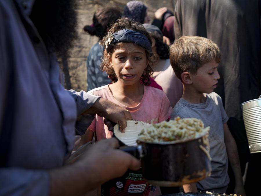 Palestinesi in fila per la distribuzione di cibo a Deir al-Balah, Striscia di Gaza. (AP Photo/Abdel Kareem Hana)