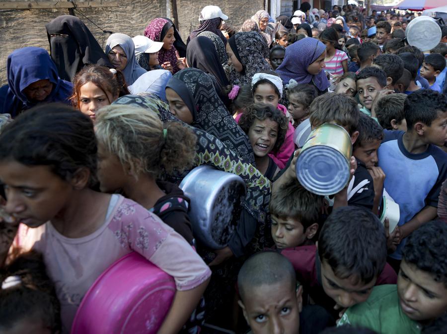 Palestinesi in fila per la distribuzione di cibo a Deir al-Balah, Striscia di Gaza. (AP Photo/Abdel Kareem Hana)