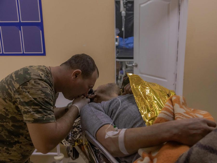 Un medico militare ucraino controlla  un militare ucraino ferito che è stato riportato dalle posizioni, in un punto di stabilizzazione della 33a Brigata Meccanizzata, vicino alla linea del fronte della città di Kurakhove, nella regione orientale di Donetsk. (Photo by Roman PILIPEY / AFP)