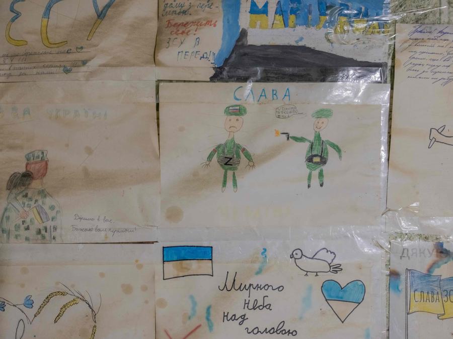 Disegni di bambini affissi a un muro in una casa trasformata dai militari ucraini della 110a Brigata Meccanizzata in un luogo militare, vicino al fronte della città di Kurakhove, nella regione orientale di Donetsk. (Photo by Roman PILIPEY / AFP)