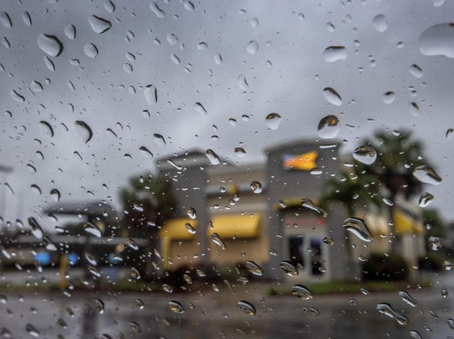Un ristorante coperto di compensato,  visto attraverso un vetro bagnato, mentre la città si prepara per l’uragano Milton a Bradenton, Florida. (EPA/Cristobal Herrera-Ulashkevich)