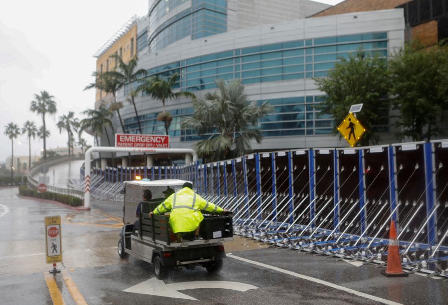 Persone in transito in un veicolo accanto a una barriera AquaFence al Tampa General Hospital, mentre si avvicina l’uragano Milton. (REUTERS/Octavio Jones)