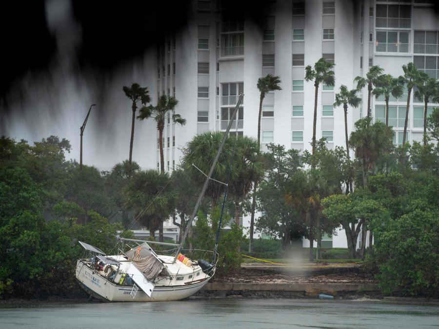 Una barca arenata da una precedente tempesta riposa sulla riva mentre l’uragano Milton si avvicina il 9 ottobre 2024 a Sarasota, Florida. (Photo by Sean Rayford / Getty Images North America / Getty Images via AFP)
