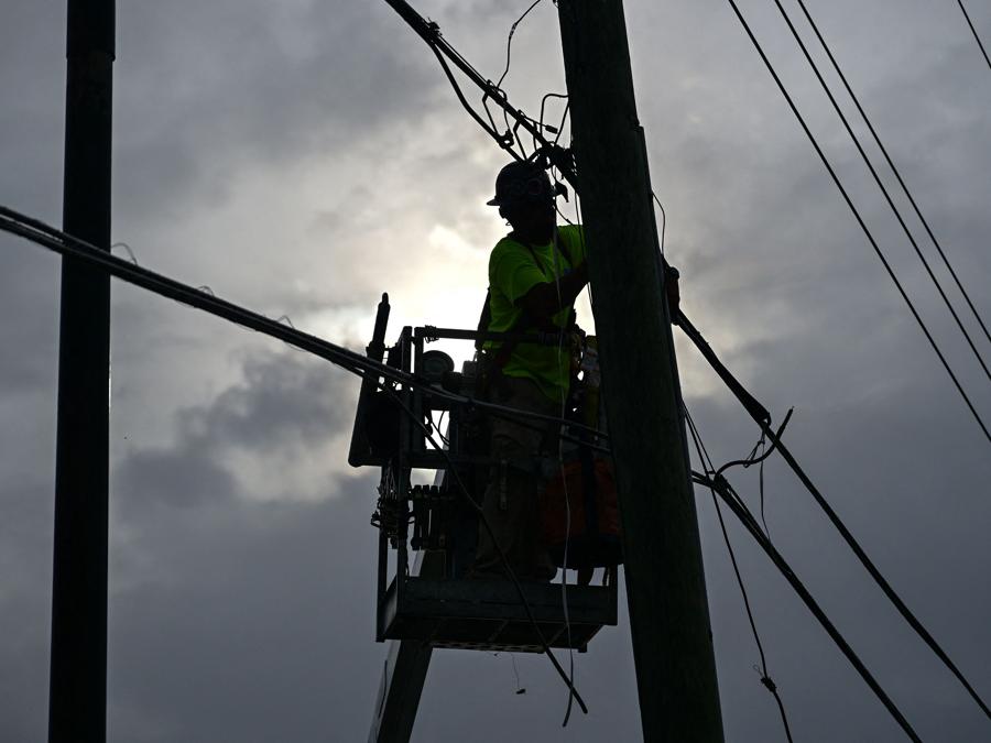 I lavoratori dei servizi Internet lavorano sui cavi sicuri a Kissimmee, Florida, prima dell’atteso arrivo dell’uragano Milton. (Photo by Giorgio Viera / AFP)